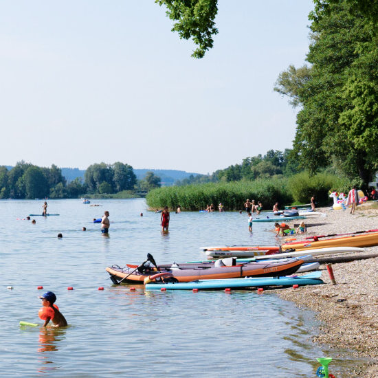 mehrere Personen, die im Waginger See baden