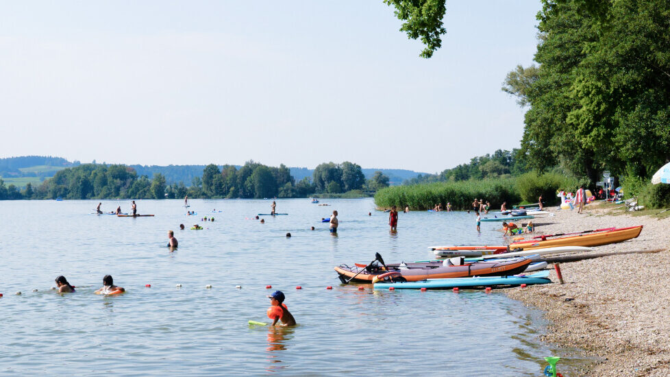 mehrere Personen, die im Waginger See baden