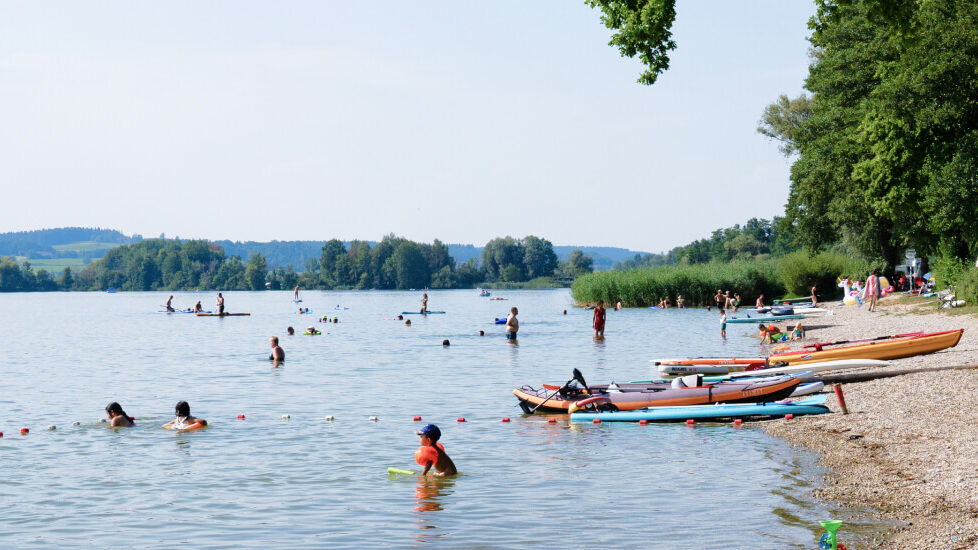 mehrere Personen, die im Waginger See baden