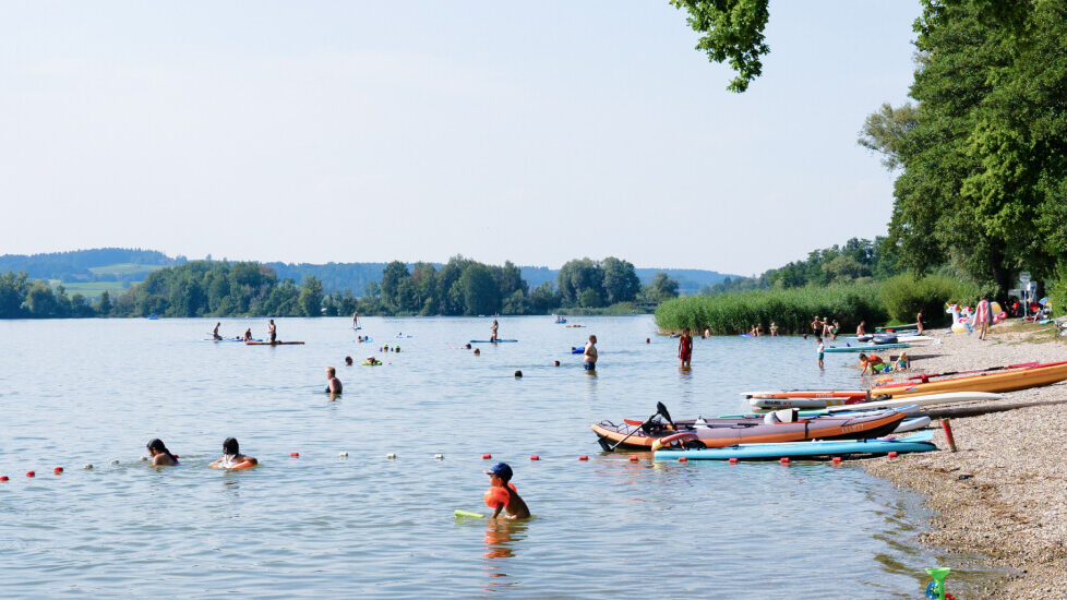 mehrere Personen, die im Waginger See baden