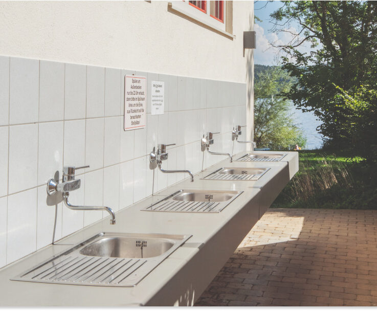 Mehrere metallene Wasch- und Spülbecken am See