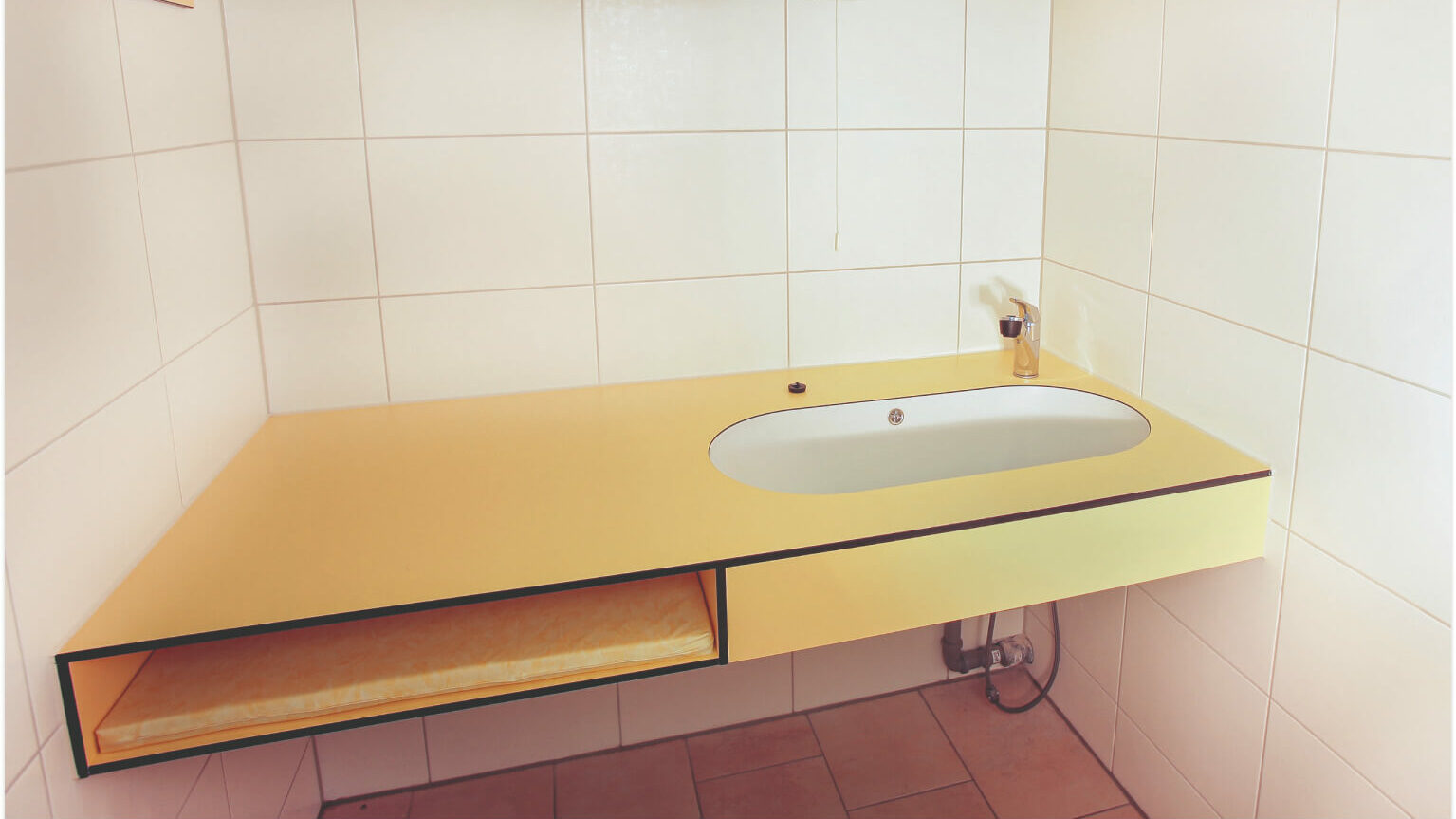 Der Wickelraum mit einem Spülbecken und einer Liegefläche