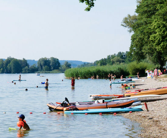 mehrere Personen, die im Waginger See baden