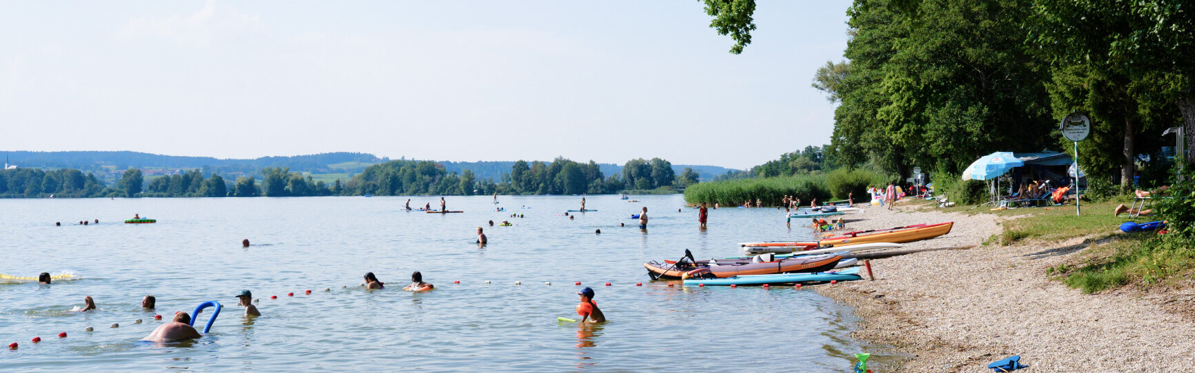 mehrere Personen, die im Waginger See baden