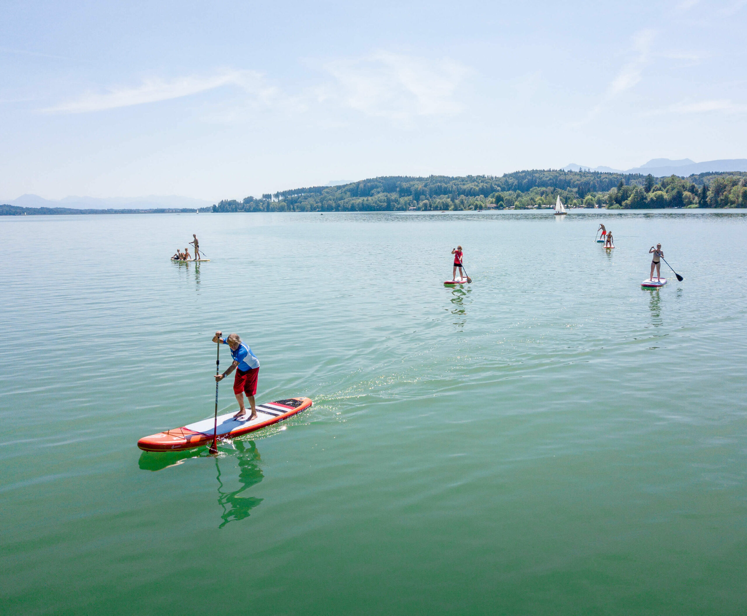 mehrere Stand-up-Paddler, die auf dem Waginger See fahren