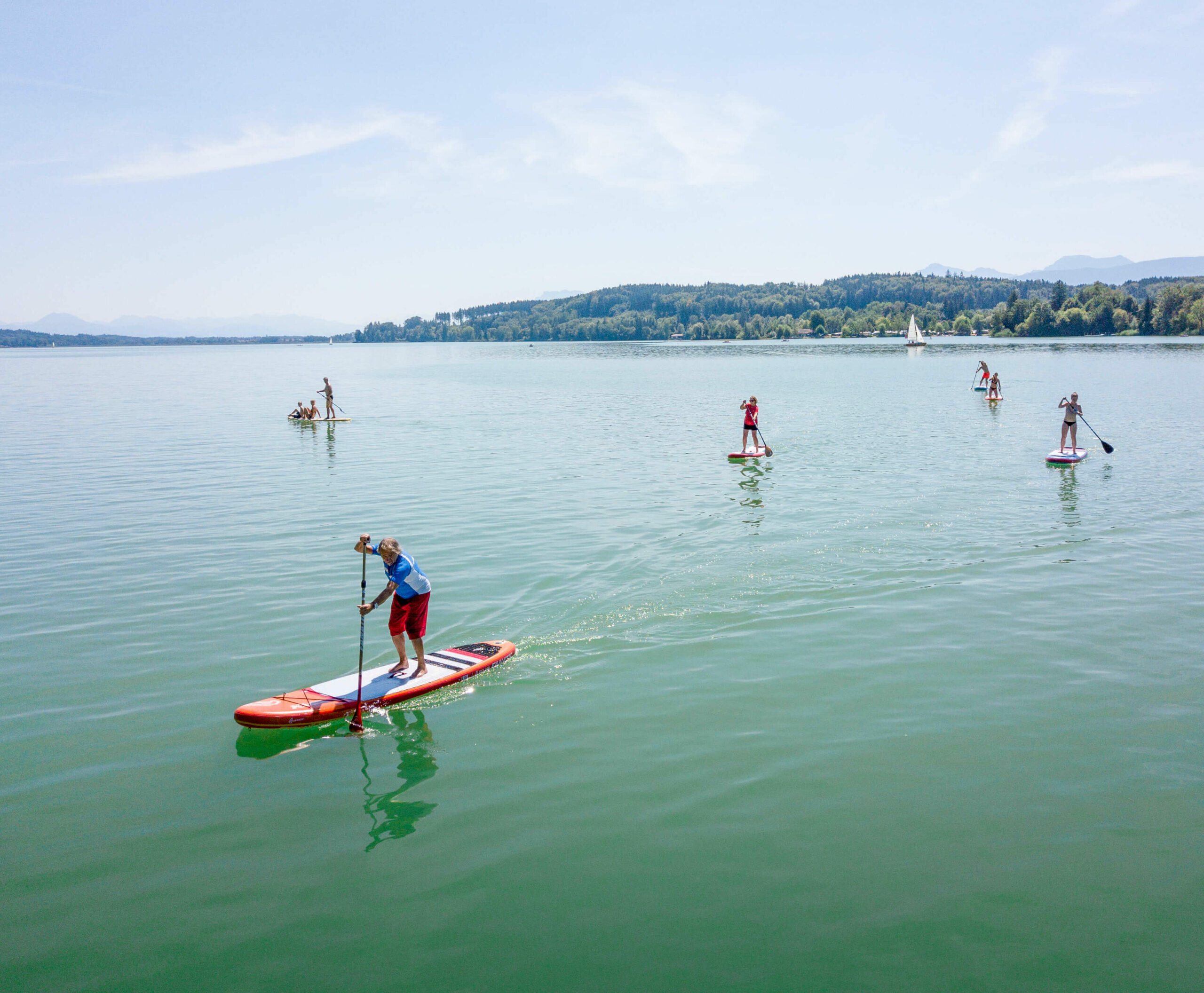 mehrere Stand-up-Paddler, die auf dem Waginger See fahren