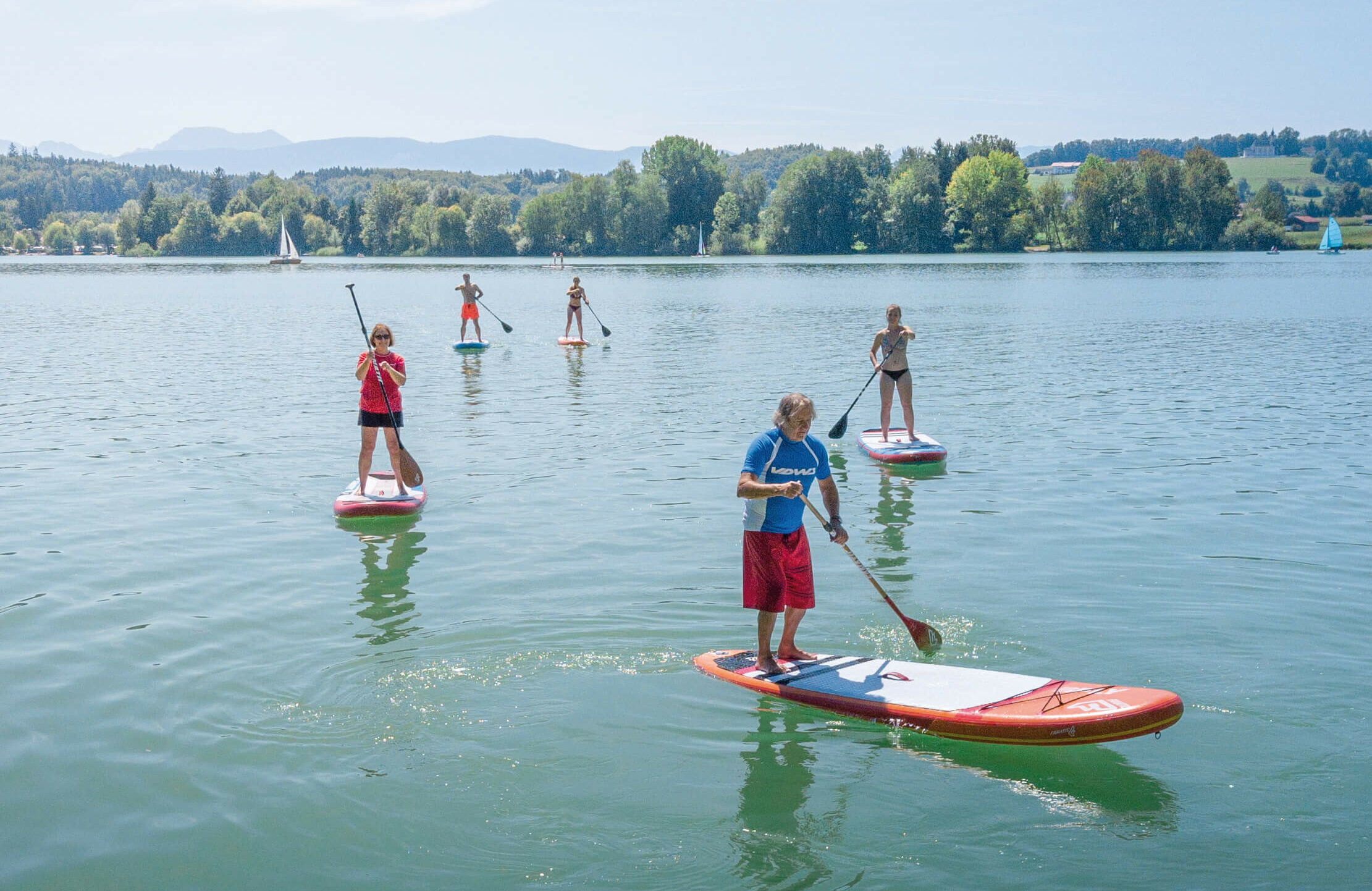 mehrere Stand-up-Paddler, die auf dem Waginger See fahren